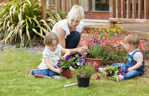 Gardener tending to plants in a garden bed